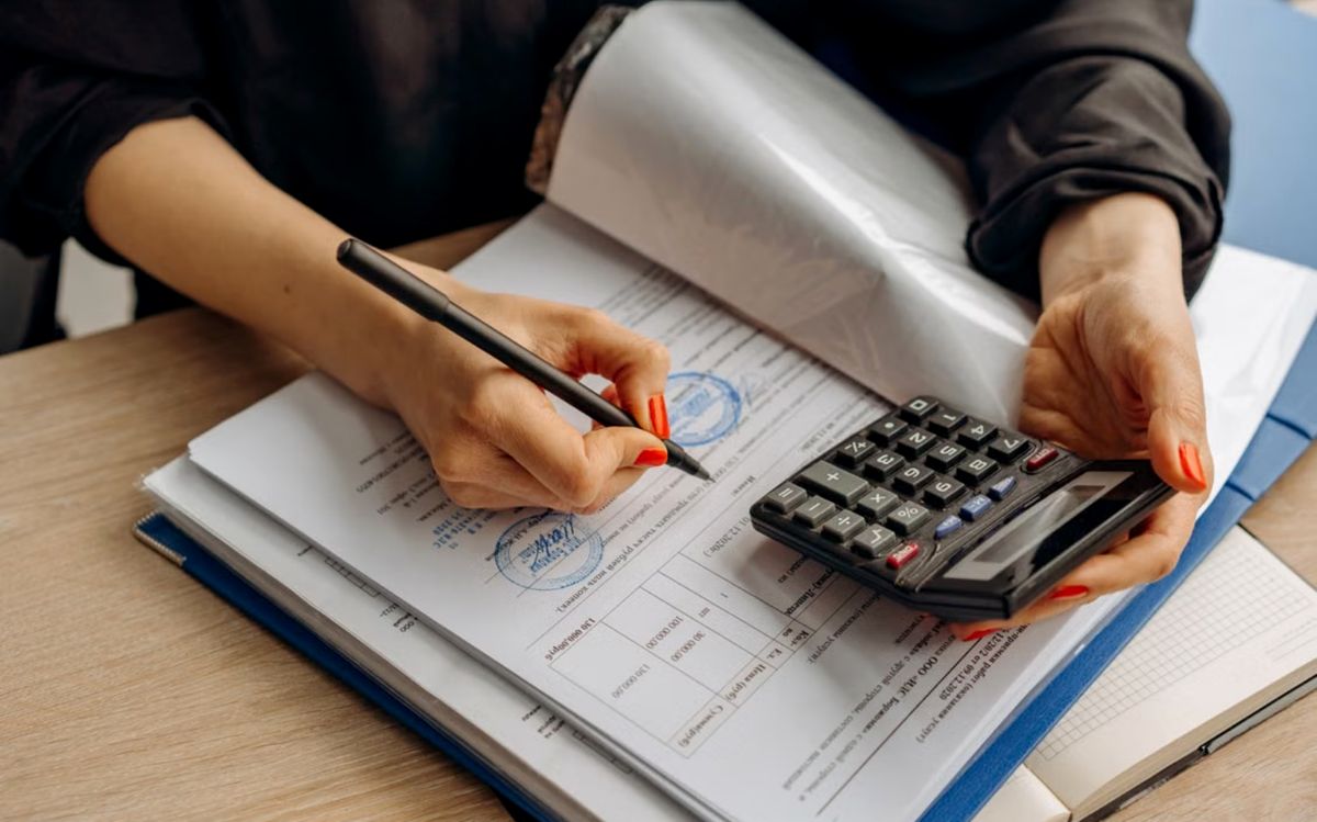 Accountant reviewing financial statements with a calculator
